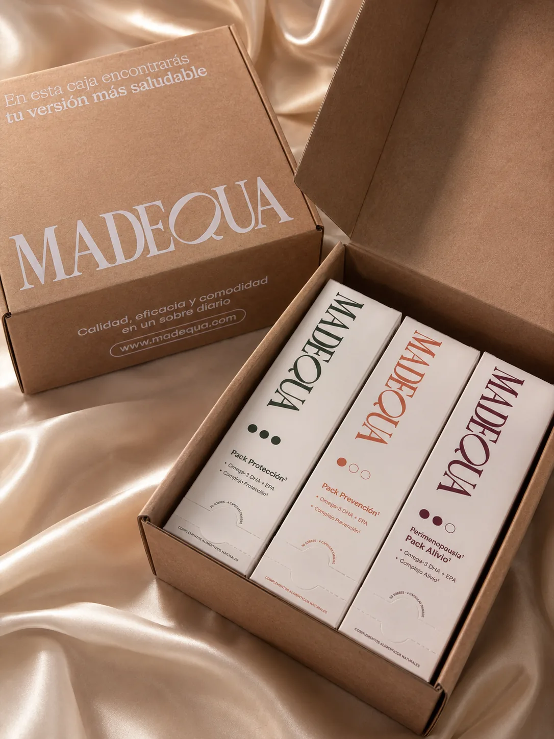 Caja de envío de Madequa abierta con los tres estuches dentro y el mensaje impreso en el interior de la tapa